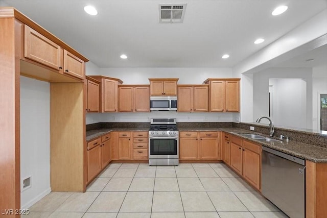4062 Vulcan St, Las Vegas, NV 89122 - kitchen with stainless steel appliances, recessed lighting, light tile patterned floors, dark stone countertops, and a peninsula