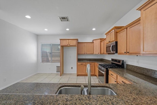 4062 Vulcan St, Las Vegas, NV 89122 - kitchen with appliances with stainless steel finishes, light tile patterned floors, recessed lighting, dark stone countertops, and brown cabinets