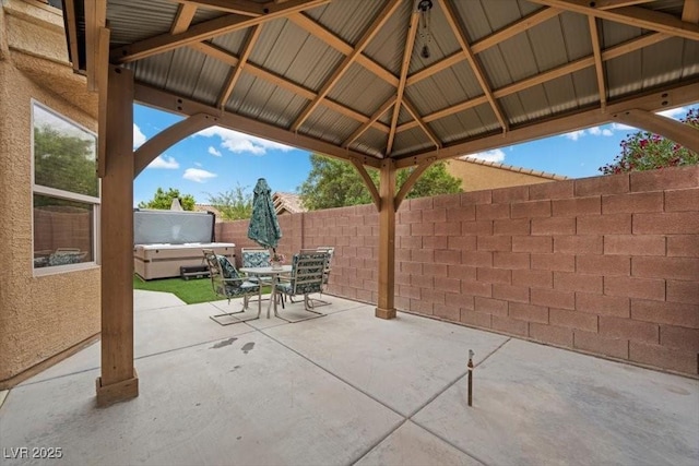 4062 Vulcan St, Las Vegas, NV 89122 - fenced backyard with a hot tub, a patio, outdoor dining area, and a gazebo