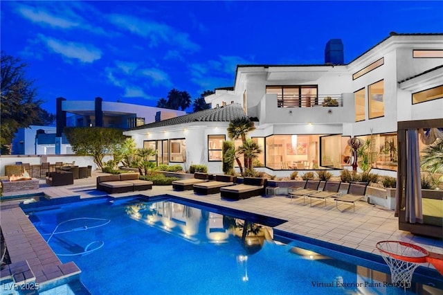 60 Innisbrook Ave, Las Vegas, NV 89113 - back of house at night featuring an outdoor living space, a patio, stucco siding, and a chimney