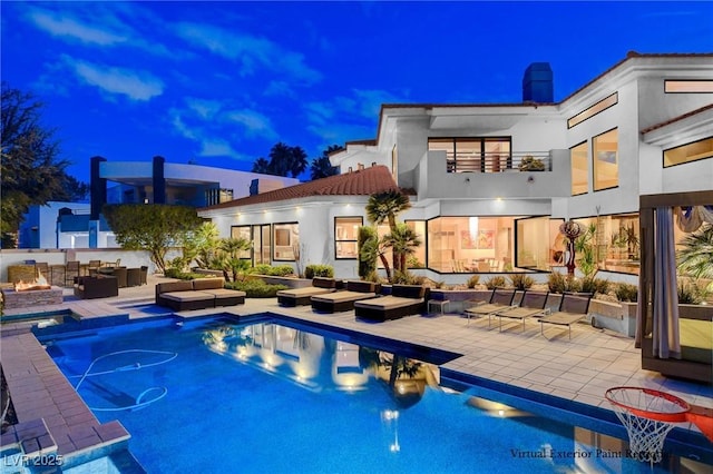 60 Innisbrook Ave, Las Vegas, NV 89113 - back of house at night with an outdoor living space, a patio, and stucco siding