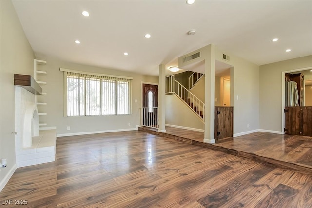 2614 Capistrano Ave, Las Vegas, NV 89121 - unfurnished living room with stairs, wood finished floors, recessed lighting, baseboards, and a fireplace with raised hearth