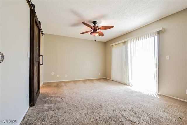 2614 Capistrano Ave, Las Vegas, NV 89121 - carpeted empty room featuring a barn door, a ceiling fan, a textured ceiling, and baseboards