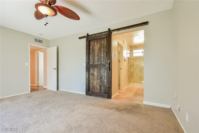 2614 Capistrano Ave, Las Vegas, NV 89121 - spare room featuring carpet floors, a ceiling fan, a barn door, and baseboards