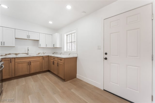 517 N 22nd St, Las Vegas, NV 89101 - kitchen with a sink, brown cabinetry, light wood finished floors, white cabinetry, and recessed lighting