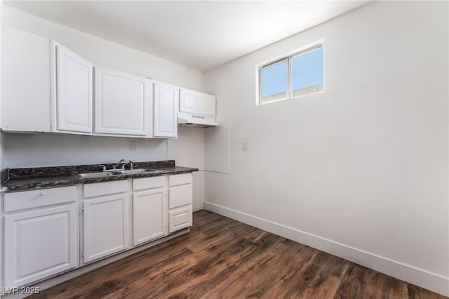 517 N 22nd St, Las Vegas, NV 89101 - kitchen with dark countertops, baseboards, a sink, white cabinetry, and dark wood-style floors