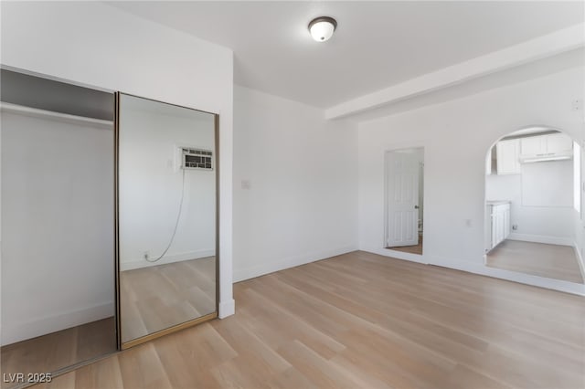 517 N 22nd St, Las Vegas, NV 89101 - unfurnished bedroom with arched walkways, light wood finished floors, a closet, and baseboards