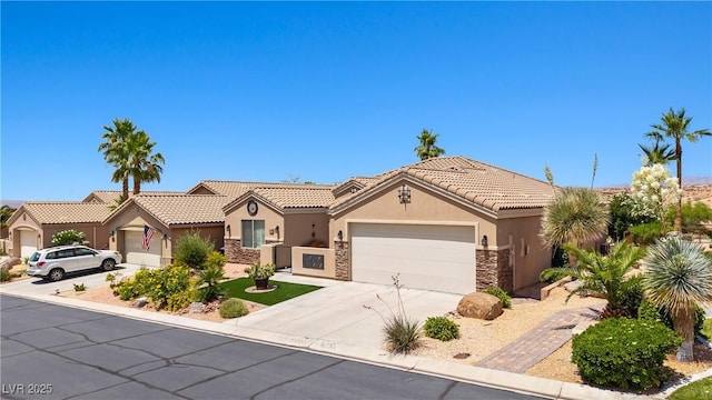 1309 Vista Del Monte Dr, Mesquite, NV 89027 - view of front facade with stone siding, stucco siding, a garage, driveway, and a tile roof