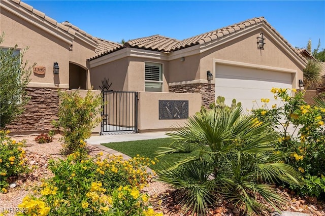 1309 Vista Del Monte Dr, Mesquite, NV 89027 - mediterranean / spanish-style house with stone siding, stucco siding, a gate, an attached garage, and a tile roof