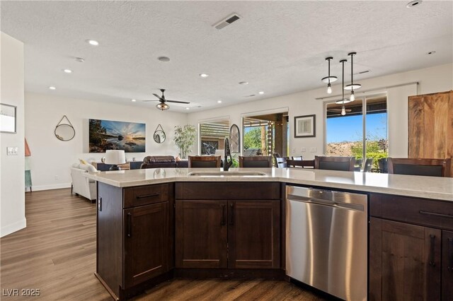 1309 Vista Del Monte Dr, Mesquite, NV 89027 - kitchen with stainless steel dishwasher, a sink, light countertops, open floor plan, and a textured ceiling