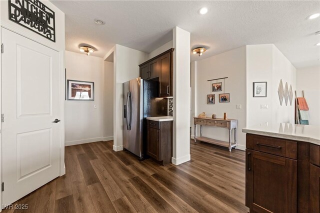 1309 Vista Del Monte Dr, Mesquite, NV 89027 - kitchen with stainless steel fridge, dark wood finished floors, light countertops, dark brown cabinets, and recessed lighting
