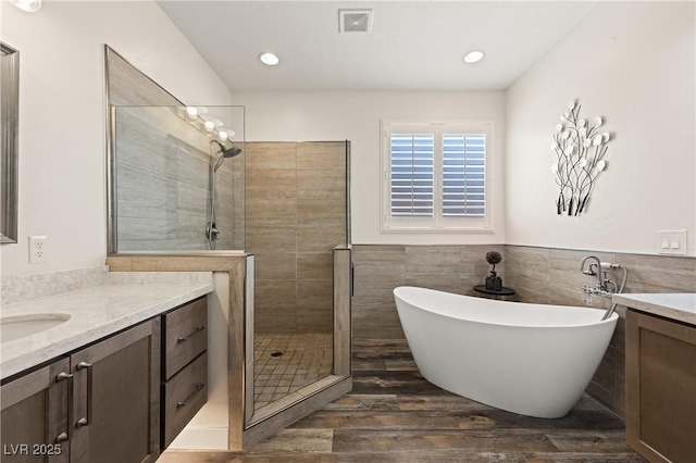 1309 Vista Del Monte Dr, Mesquite, NV 89027 - full bath featuring vanity, a shower stall, a freestanding tub, wood finished floors, and a wainscoted wall