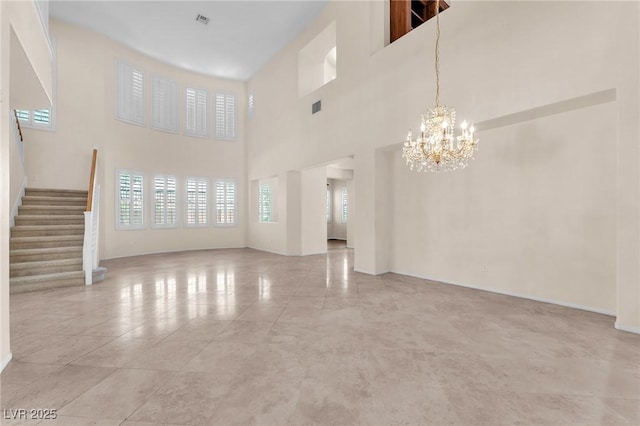 1155 Phillip Island St, Henderson, NV 89052 - unfurnished living room with a chandelier, stairway, a towering ceiling, and light tile patterned flooring