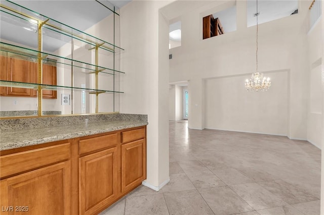 1155 Phillip Island St, Henderson, NV 89052 - bar area featuring a chandelier, light tile patterned flooring, a high ceiling, and hanging light fixtures