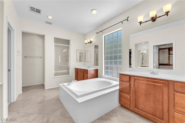 1155 Phillip Island St, Henderson, NV 89052 - full bathroom featuring a garden tub, a stall shower, two vanities, and tile patterned flooring