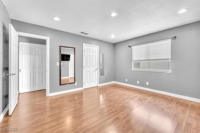 5012 Newport Cove Dr Unit C, Las Vegas, NV 89119 - unfurnished bedroom with light wood-style floors, baseboards, a textured ceiling, and recessed lighting