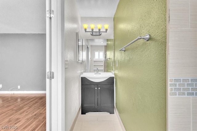 5012 Newport Cove Dr Unit C, Las Vegas, NV 89119 - bathroom with a textured wall, vanity, baseboards, and wood finished floors