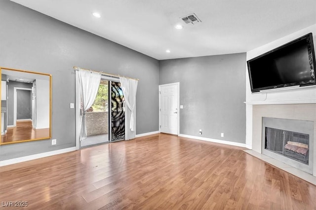 5012 Newport Cove Dr Unit C, Las Vegas, NV 89119 - unfurnished living room with wood finished floors, baseboards, recessed lighting, and a fireplace