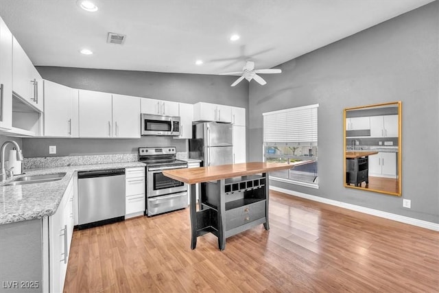 5012 Newport Cove Dr Unit C, Las Vegas, NV 89119 - kitchen with appliances with stainless steel finishes, a sink, lofted ceiling, a ceiling fan, and light wood finished floors