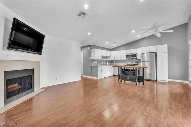 5012 Newport Cove Dr Unit C, Las Vegas, NV 89119 - kitchen with stainless steel appliances, vaulted ceiling, white cabinets, light countertops, and ceiling fan