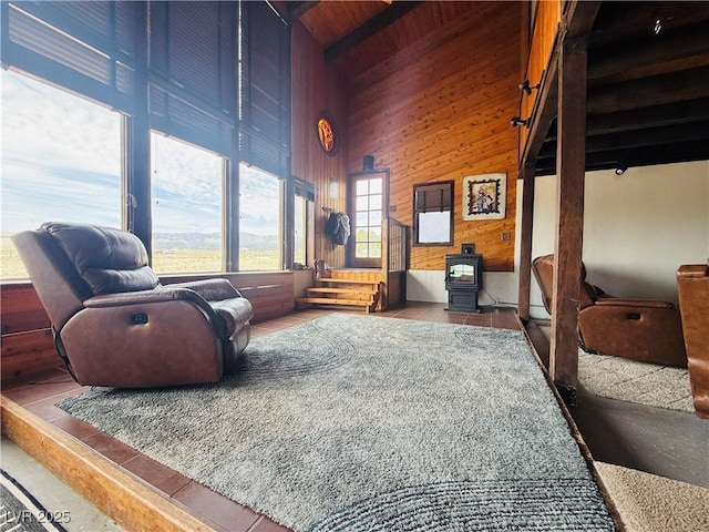 250 E Madison Ave, Ely, NV 89301 - sitting room with high vaulted ceiling, a wood stove, wood ceiling with exposed beams, and wooden walls