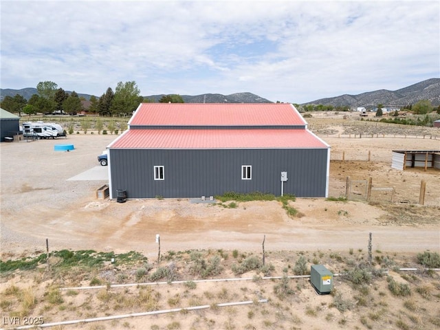 250 E Madison Ave, Ely, NV 89301 - view of property exterior featuring an outbuilding, metal roof, a mountain view, and an outdoor structure