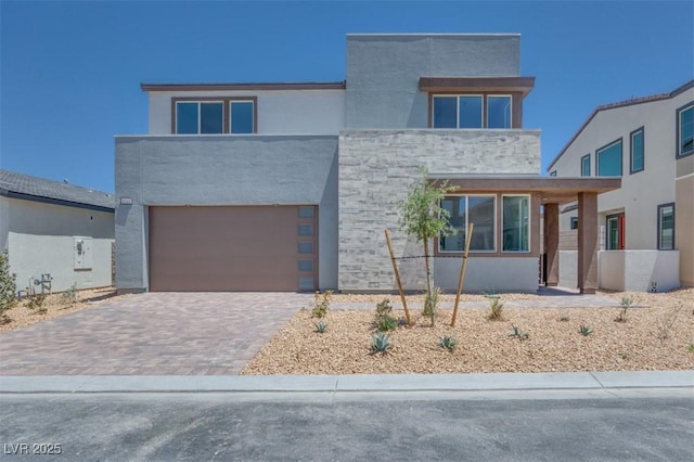 9265 Frazer St, Las Vegas, NV 89166 - contemporary house with an attached garage, decorative driveway, stucco siding, and stone siding