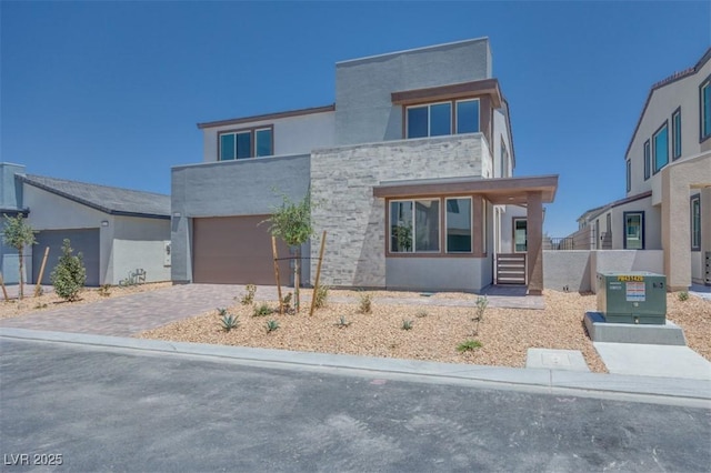 9265 Frazer St, Las Vegas, NV 89166 - contemporary home with a garage, driveway, stucco siding, and stone siding