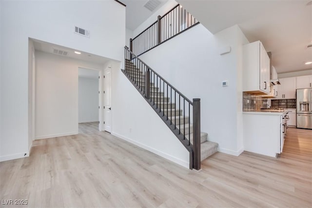 9265 Frazer St, Las Vegas, NV 89166 - stairs with wood finished floors, baseboards, a towering ceiling, and recessed lighting