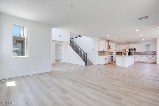 9265 Frazer St, Las Vegas, NV 89166 - unfurnished living room with stairway, light wood-type flooring, recessed lighting, and baseboards