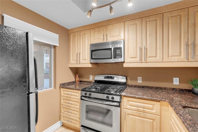 270 E Flamingo Rd Unit 131, Las Vegas, NV 89169 - kitchen with stainless steel appliances, light brown cabinets, dark stone countertops, and baseboards