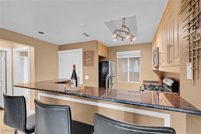 270 E Flamingo Rd Unit 131, Las Vegas, NV 89169 - kitchen featuring freestanding refrigerator, stainless steel microwave, range with gas stovetop, and dark stone countertops