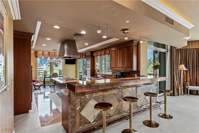 1 Hughes Center Dr Unit 308, Las Vegas, NV 89169 - kitchen with island exhaust hood, a sink, a breakfast bar, recessed lighting, and a peninsula