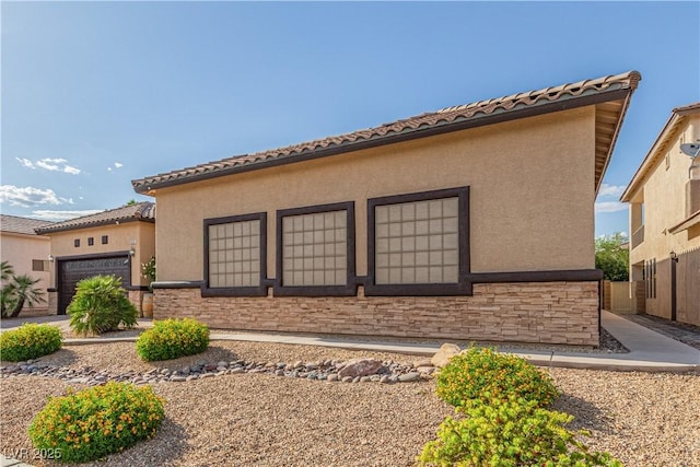 5576 Buena Martina Way, Las Vegas, NV 89141 - view of property exterior with a garage, stucco siding, stone siding, and a tiled roof