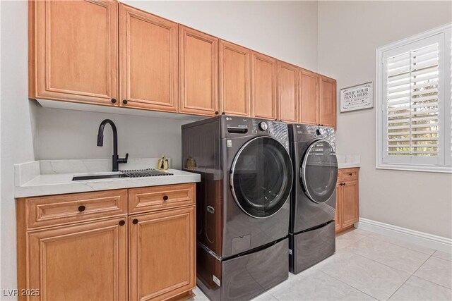 5576 Buena Martina Way, Las Vegas, NV 89141 - washroom featuring cabinet space, washer and clothes dryer, light tile patterned floors, and baseboards