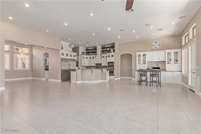 5576 Buena Martina Way, Las Vegas, NV 89141 - living area with arched walkways, a chandelier, light tile patterned floors, recessed lighting, and baseboards