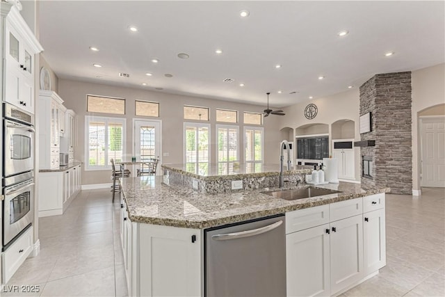 5576 Buena Martina Way, Las Vegas, NV 89141 - kitchen with appliances with stainless steel finishes, a sink, a large island with sink, recessed lighting, and light tile patterned floors