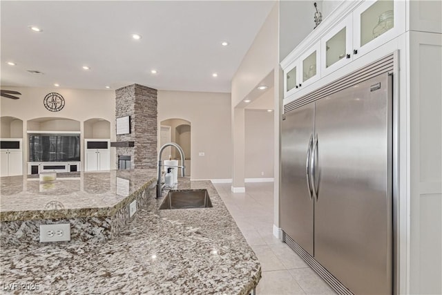 5576 Buena Martina Way, Las Vegas, NV 89141 - kitchen with built in refrigerator, a sink, arched walkways, light stone counters, and recessed lighting
