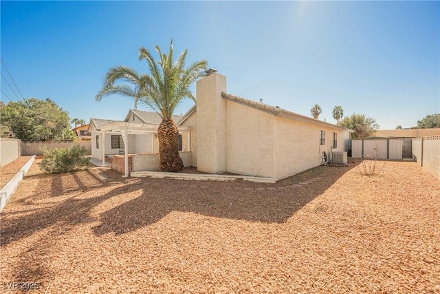 2004 Canterbury Dr, Las Vegas, NV 89119 - back of property with stucco siding, a fenced backyard, and central AC