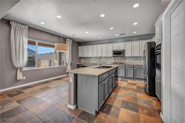 2449 Daks Loden Ct, Henderson, NV 89044 - kitchen featuring appliances with stainless steel finishes, a sink, tasteful backsplash, a kitchen island with sink, and recessed lighting