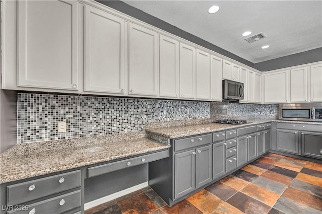 2449 Daks Loden Ct, Henderson, NV 89044 - kitchen with gray cabinets, stainless steel microwave, gas stovetop, dark stone finish flooring, and recessed lighting