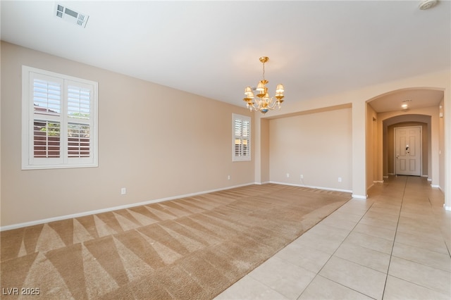 11238 Meadow Cove St, Las Vegas, NV 89179 - empty room featuring arched walkways, a chandelier, baseboards, light tile patterned floors, and light carpet