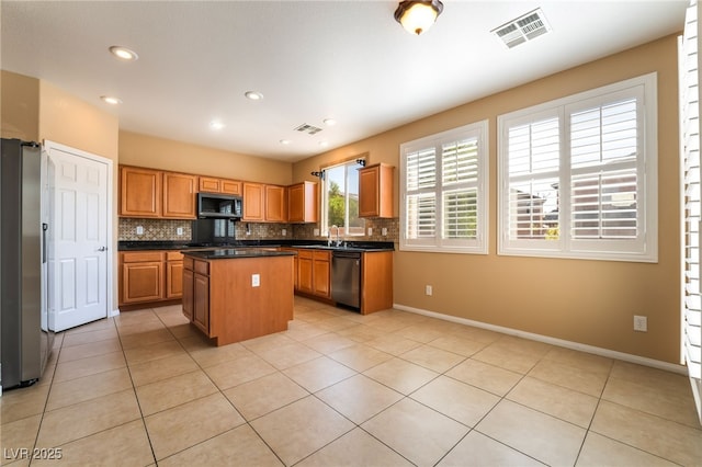 11238 Meadow Cove St, Las Vegas, NV 89179 - kitchen with stainless steel appliances, a center island, dark countertops, backsplash, and recessed lighting