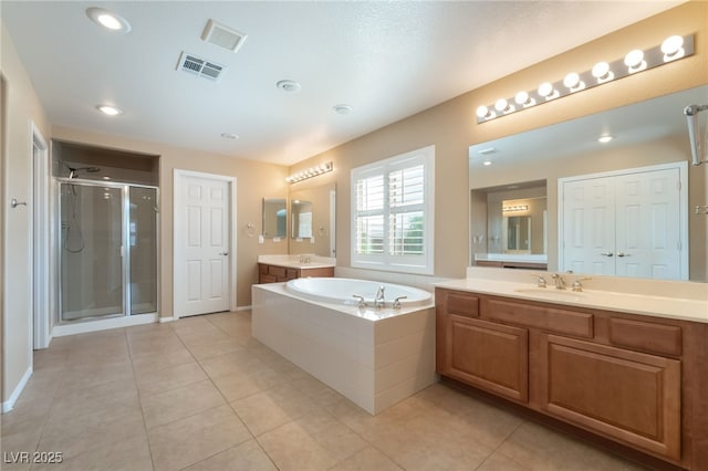 11238 Meadow Cove St, Las Vegas, NV 89179 - bathroom with a stall shower, two vanities, a garden tub, tile patterned floors, and recessed lighting