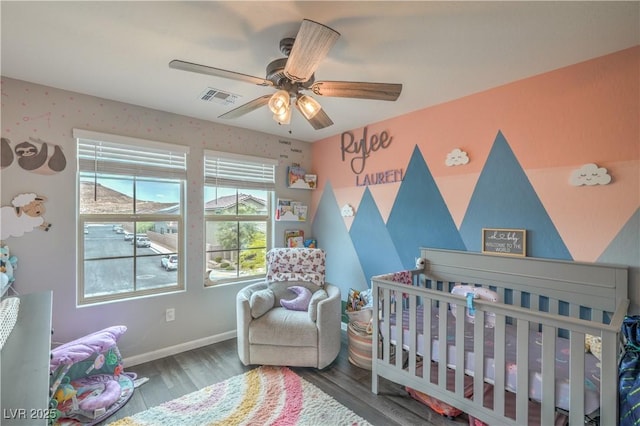 10031 Fletcher Peak Ave, Las Vegas, NV 89178 - bedroom featuring a nursery area, wood finished floors, baseboards, and a ceiling fan