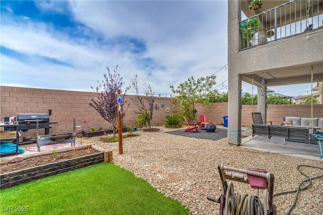 10031 Fletcher Peak Ave, Las Vegas, NV 89178 - fenced backyard with an outdoor hangout area, a patio area, and a vegetable garden