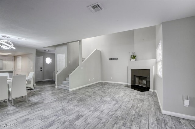 6250 W Flamingo Rd Unit 43, Las Vegas, NV 89103 - unfurnished living room with wood finished floors, baseboards, stairway, and a fireplace with flush hearth