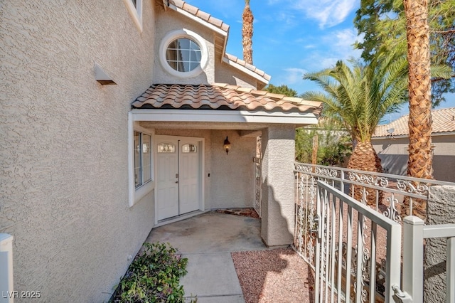 125 Firecreek Cir, Las Vegas, NV 89107 - doorway to property with stucco siding, a tile roof, and a balcony