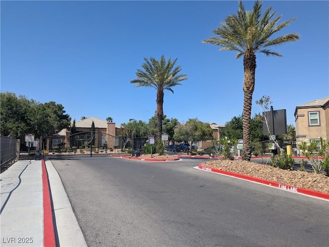 6650 W Warm Springs Rd Unit 2159, Las Vegas, NV 89118 - view of asphalt road with curbs, a gated entry, and a gate