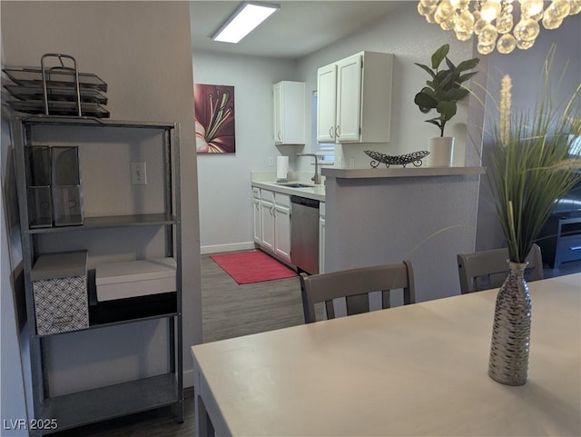 6650 W Warm Springs Rd Unit 2159, Las Vegas, NV 89118 - kitchen featuring stainless steel dishwasher, a sink, dark wood-type flooring, a chandelier, and light countertops